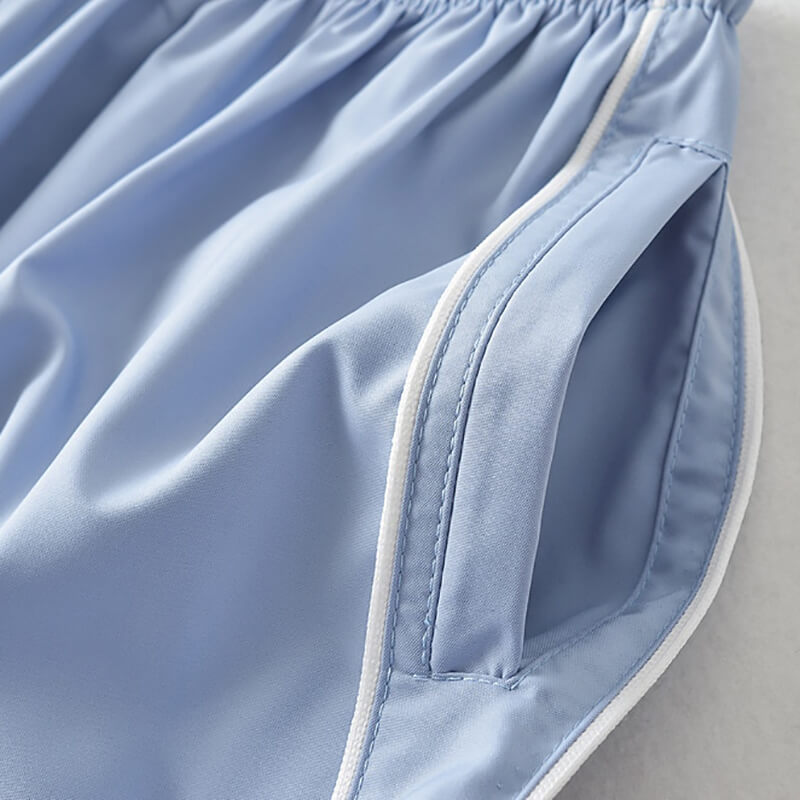 Close-up of light blue high-waisted women’s sweatpants with pocket detail, showcasing breathable polyester fabric and stylish design.